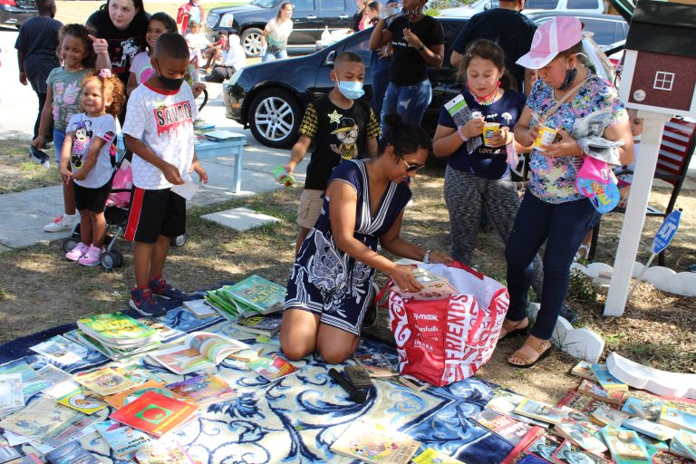 Children choosing free books at an outdoor community event