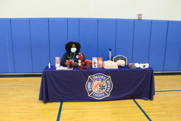 A community partner information table at a family event in a school gym