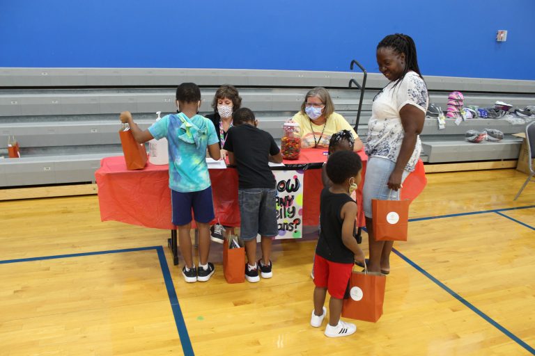 Children taking part in a hands-on activity at a family event in a school gym